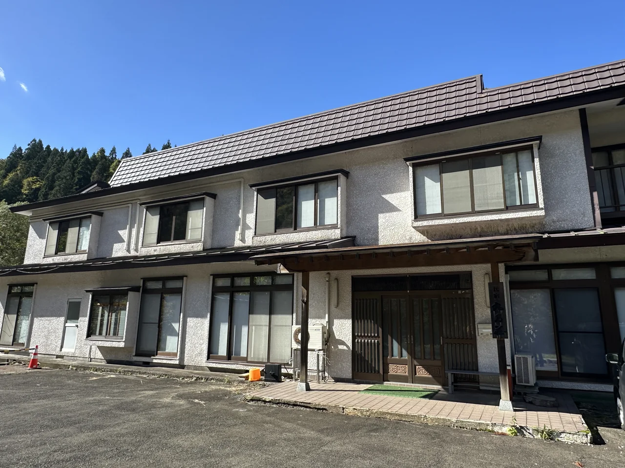 青空の下に建つ温泉民宿 丸乃荘の外観